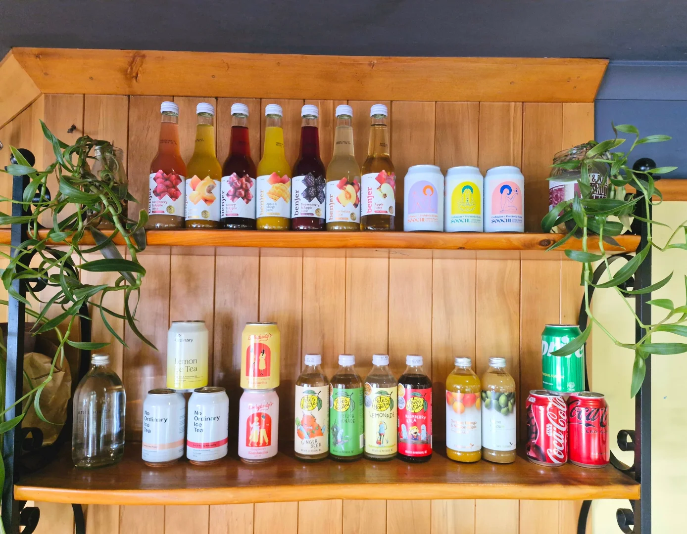 Colourful bottled drinks displayed on timber shelves at Sime's Kitchen